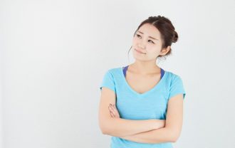 腕御組んで遠くを見つめる女性