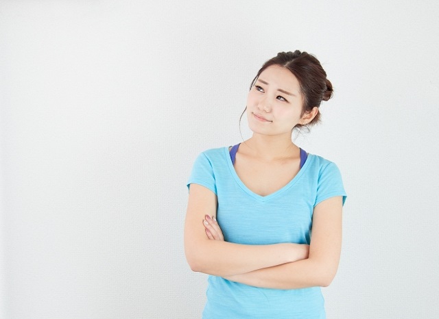 腕御組んで遠くを見つめる女性